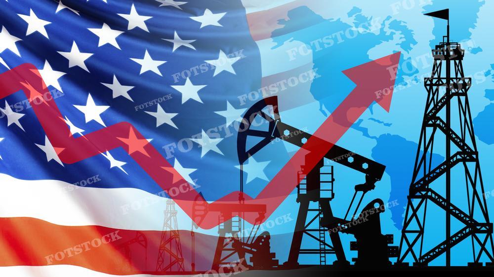 На фотографии изображены силуэты нефтяных вышек на фоне Американского флага и красной стрелки, направленной вверх, символизирующей рост. Фон смешивает элементы флага и географической карты, что может олицетворять роль Соединенных Штатов в мировой нефтяной промышленности или положительные тенденции в американской экономике, связанные с энергетическим сектором. Это изображение подходит для использования в материалах, посвященных энергетической политике, рынку нефти или экономическом росте США.